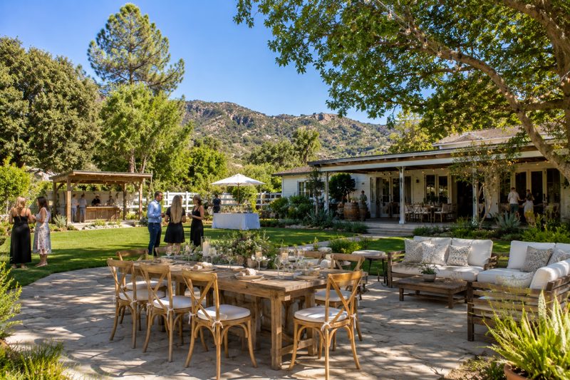 Ranch-style San Fernando Valley backyard with hills, mature trees, and outdoor seating