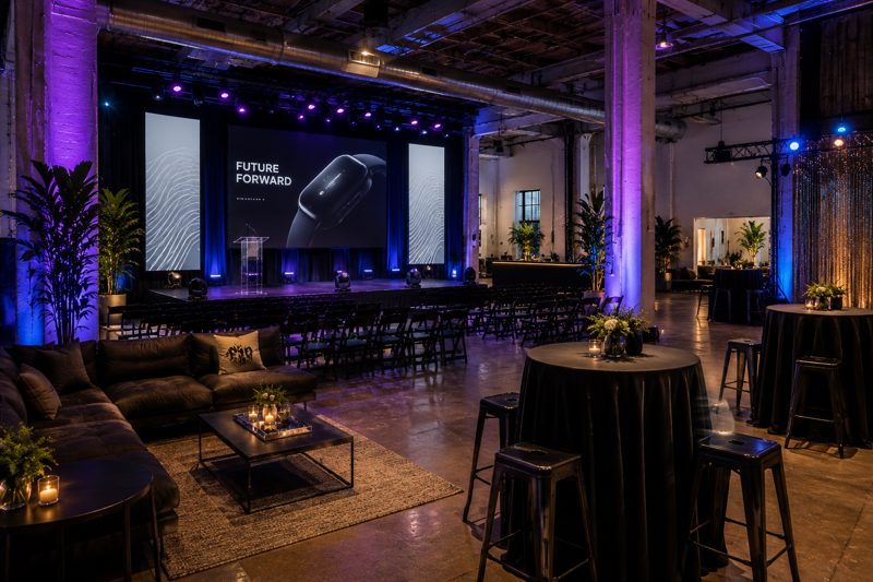 Modern New York creative event space with presentation stage, screen, cocktail tables, production lighting, and lounge seating