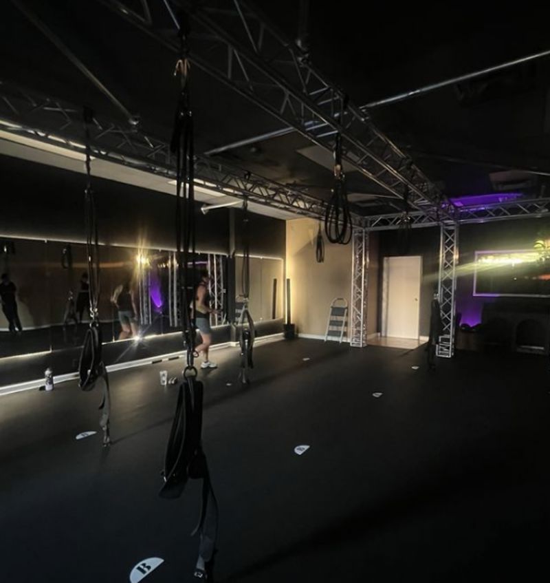 Modern Boutique Fitness Studio with Bungee Rigs, Mirrored Wall, and Mood Lighting